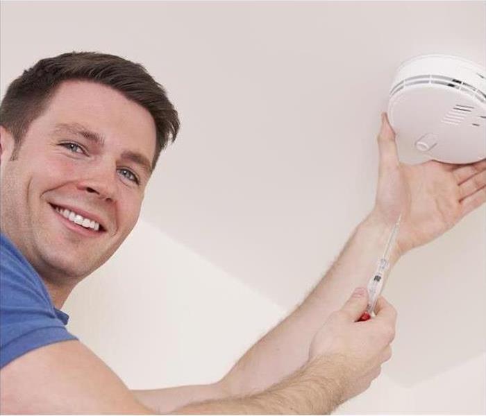 Man changing Carbon Monoxide alarm